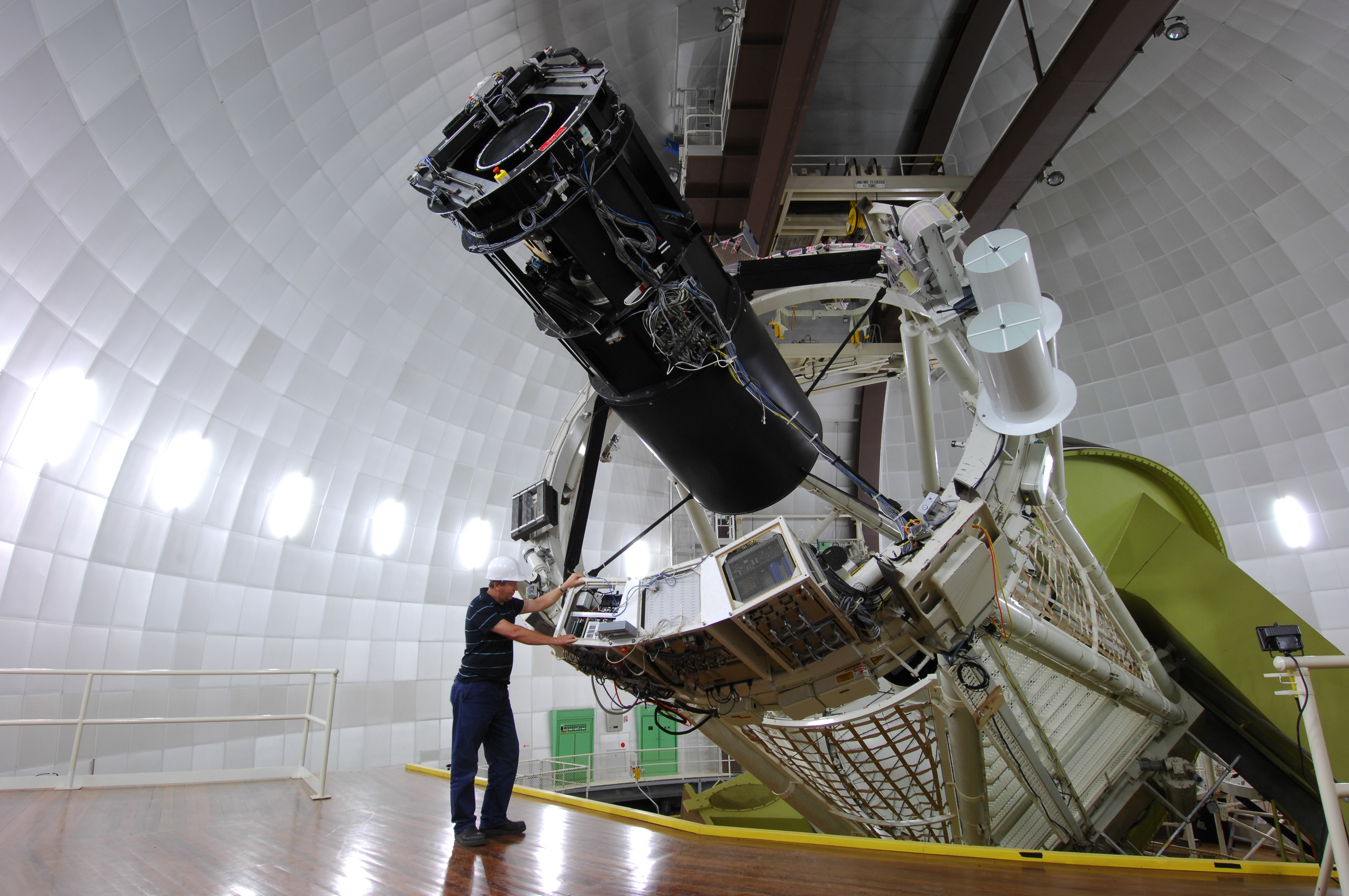 This picture shows the Anglo-Australian Telescope (with a yellow horseshoe mount and its topend with the 2dF Positioner